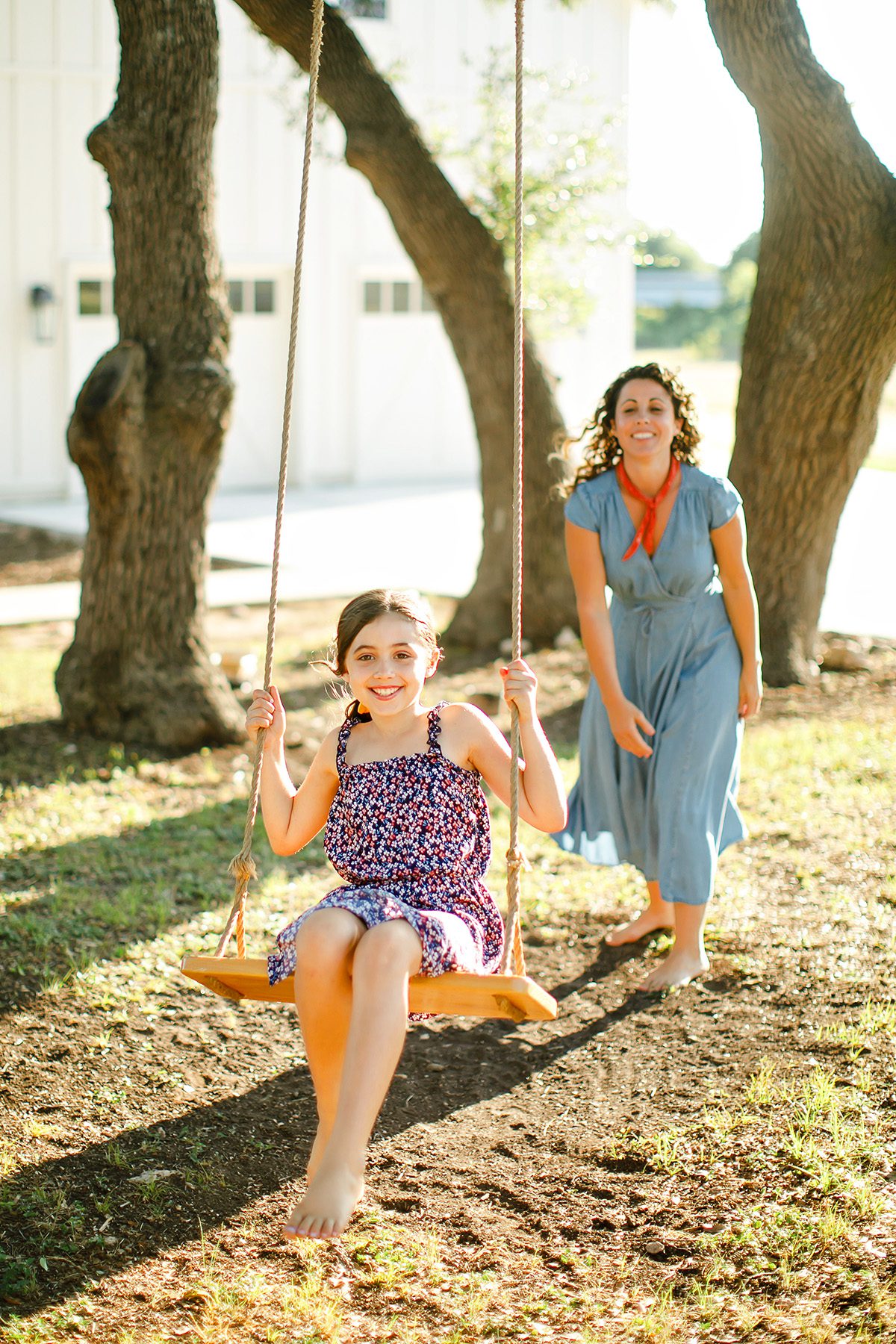 Christina Caster pushing her daughter Blue on a tree swing in Dripping Springs, Texas