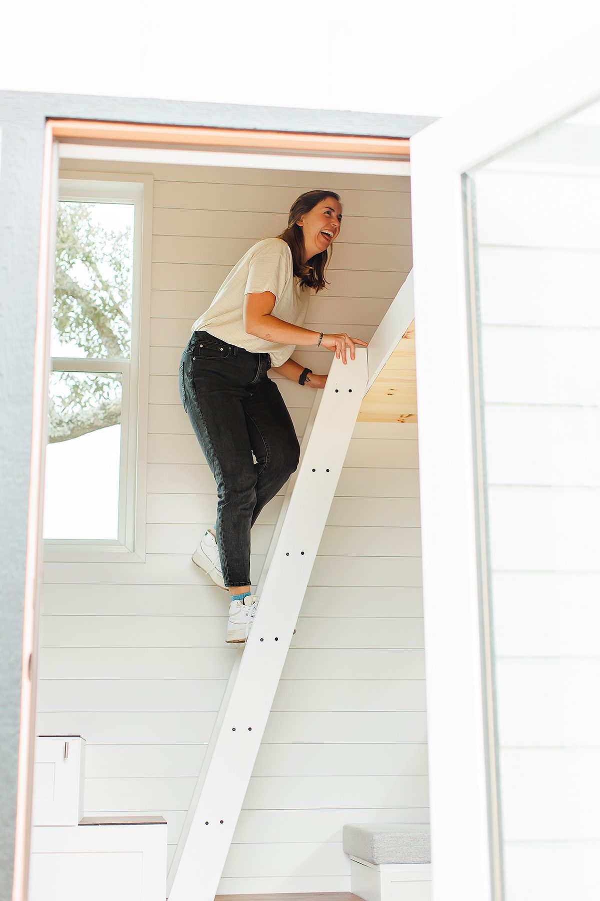 Emily Weyand, Dripping Springs High School math teacher, climbing a ladder in her tiny house