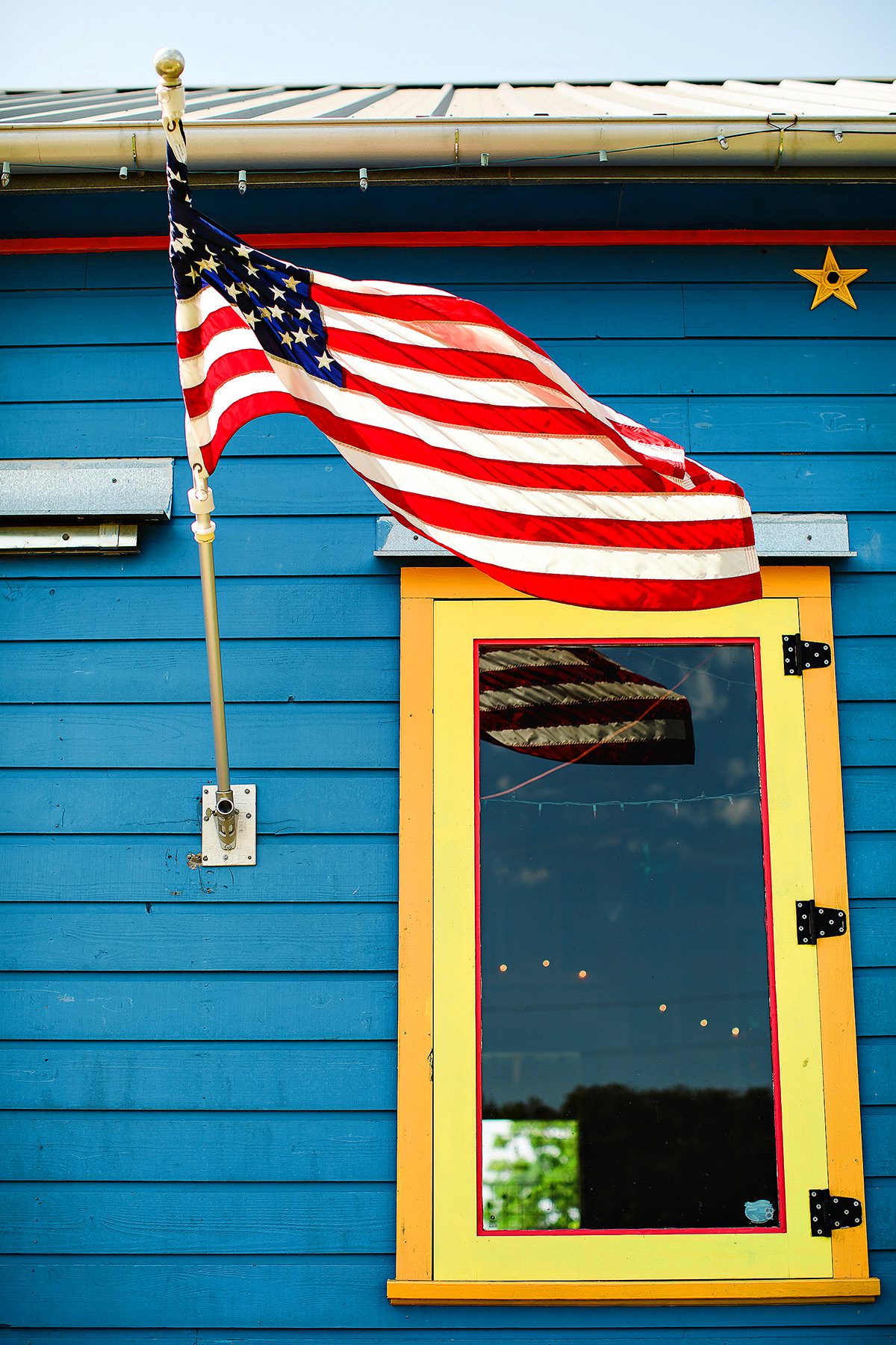 Arnosky Family Farm blue barn with flag in Wimberley, Texas 