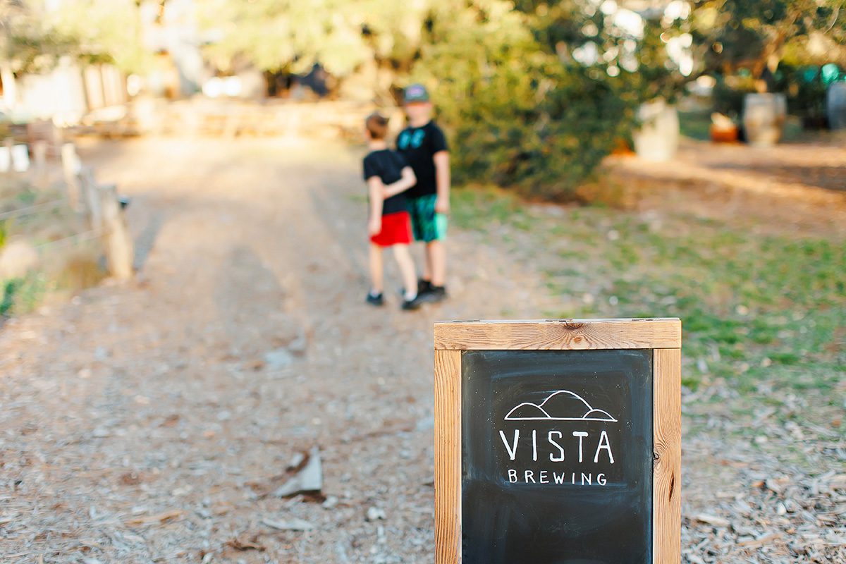 kids walking by Vista Brewing sign